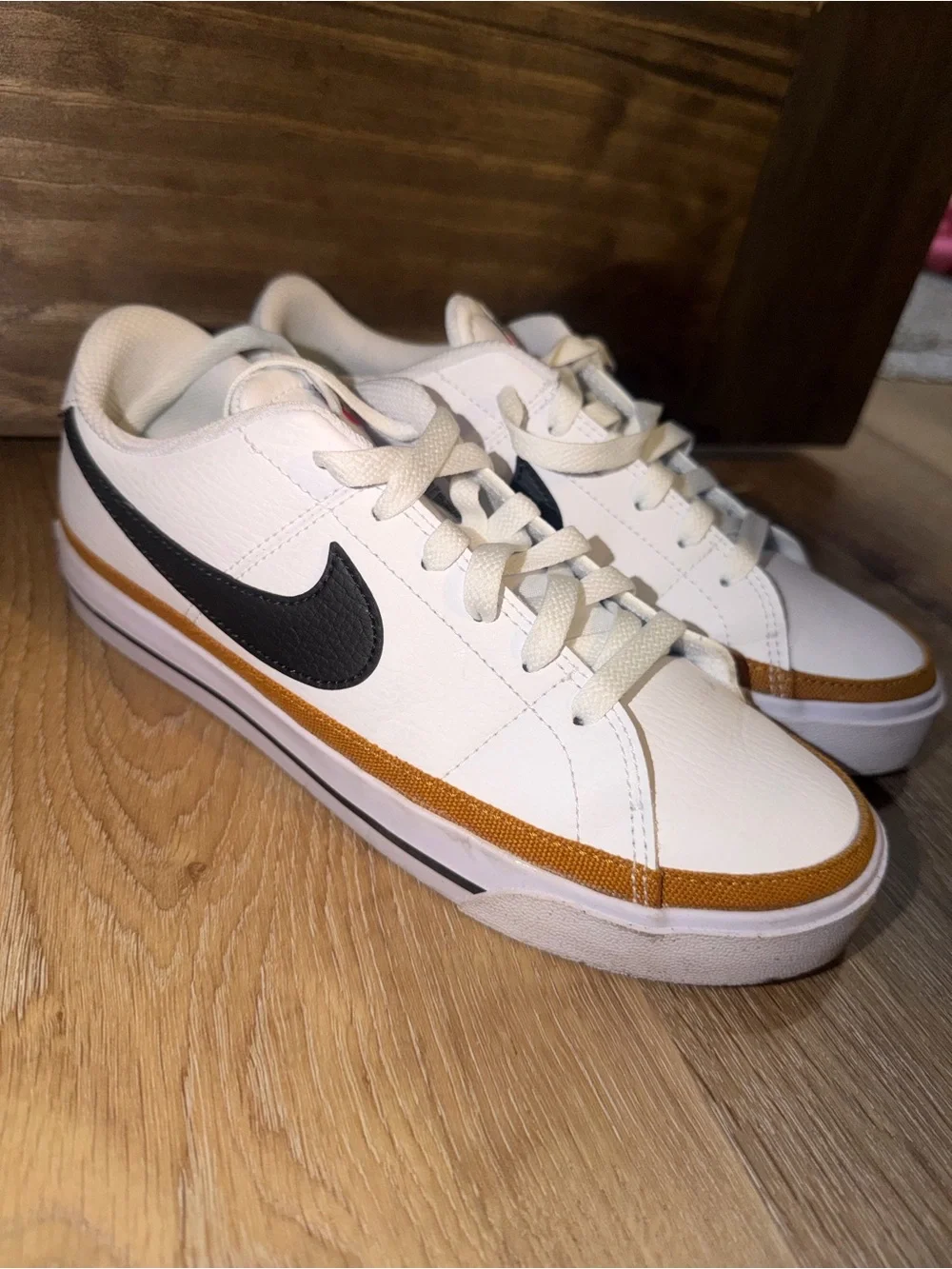 Nike Women’s White Low-Top Sneakers with Black Swoosh and Gold Accent